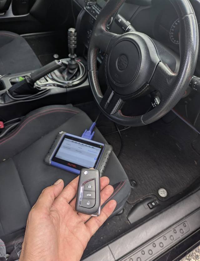 Diagnostic tool programming a Toyota key inside a customer's car